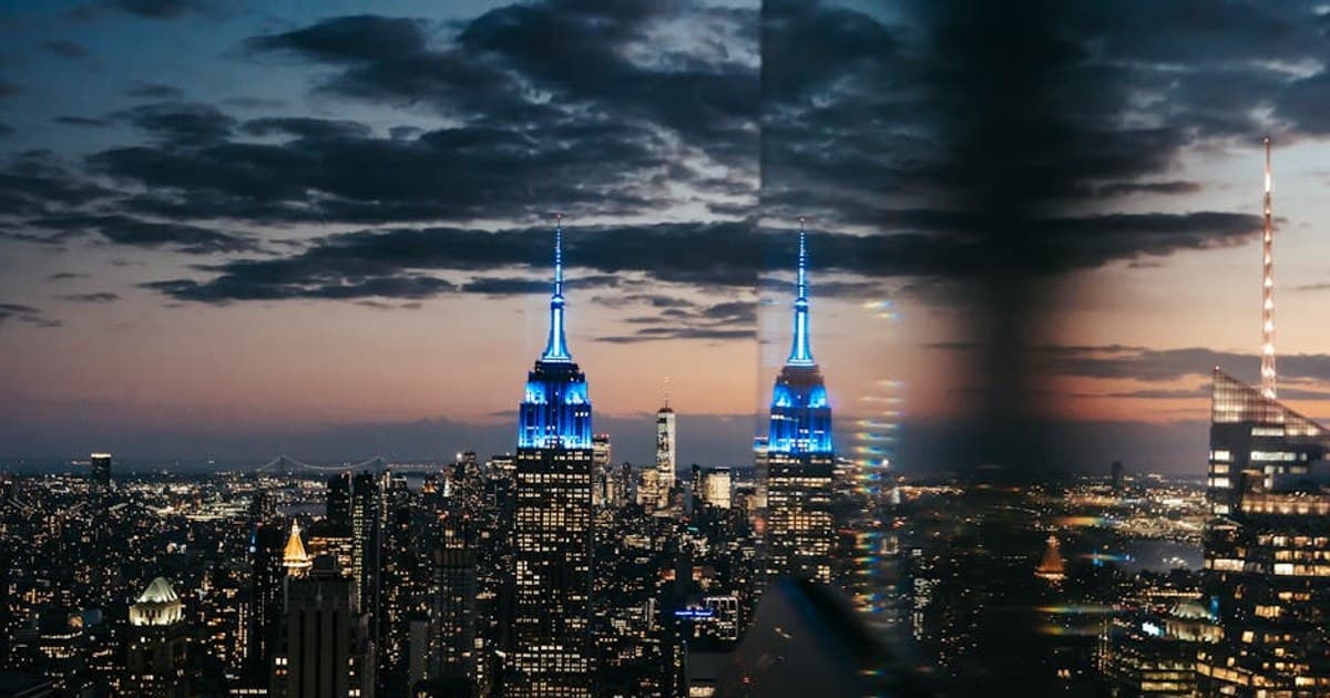 View trough glass window on skyscraper illuminated by bright blue lights located in downtown of New York City in America in twilight