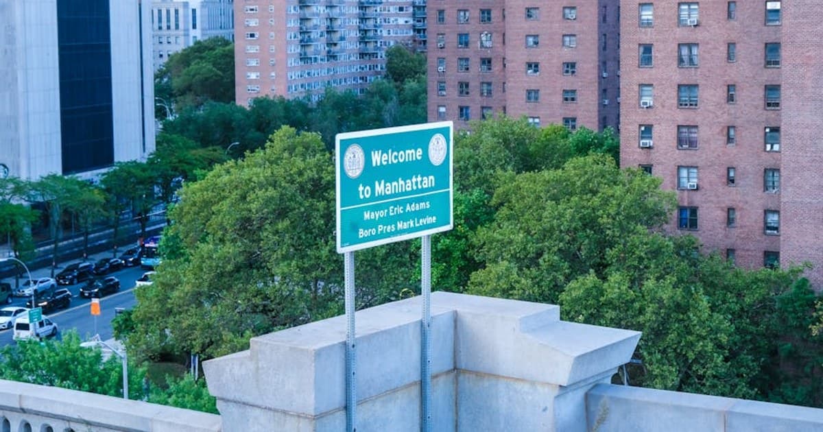Overview of Manhattan with a welcome sign and urban architecture in New York City.