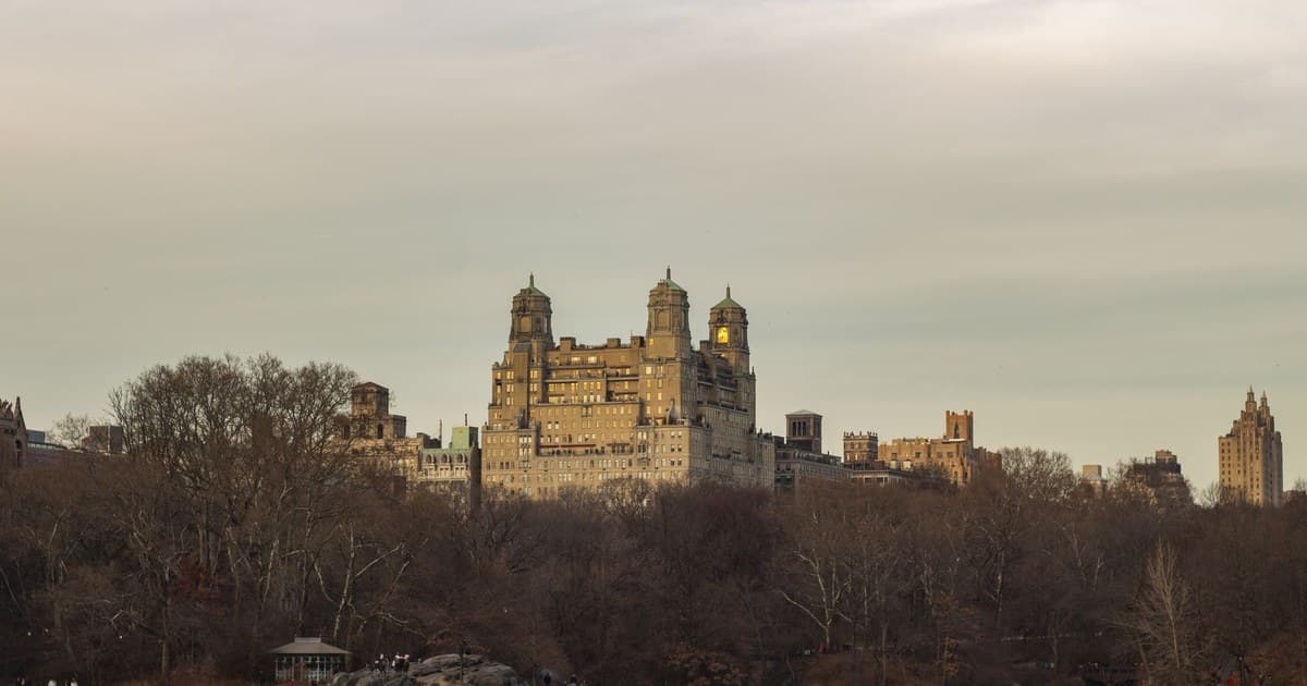 Scenic view of The Beresford building amidst trees in Central Park, NYC.