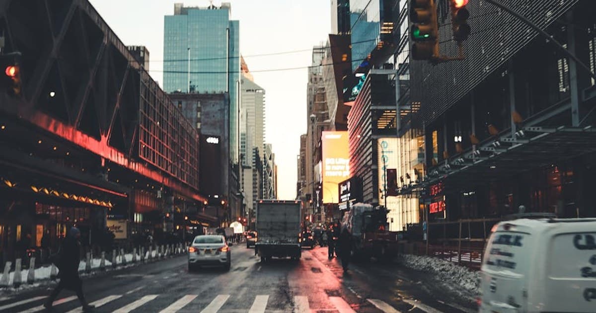 Iconic New York City street scene at twilight with traffic and skyscrapers.
