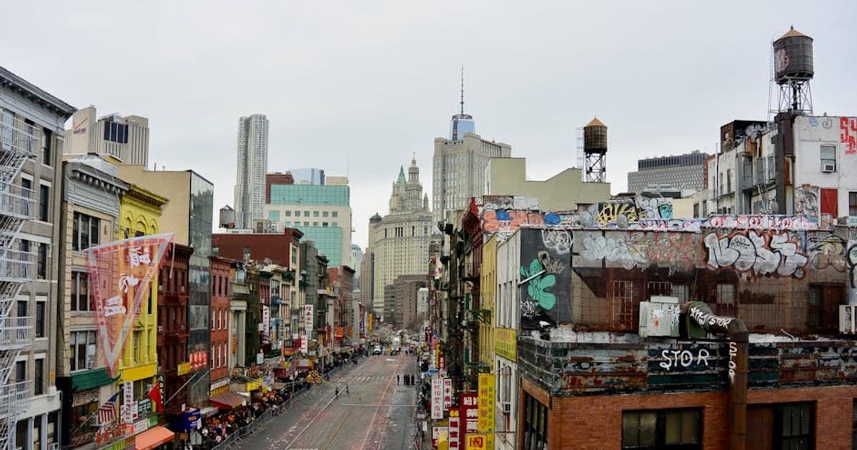 A bustling street in New York City's Chinatown showcasing colorful buildings and urban graffiti.