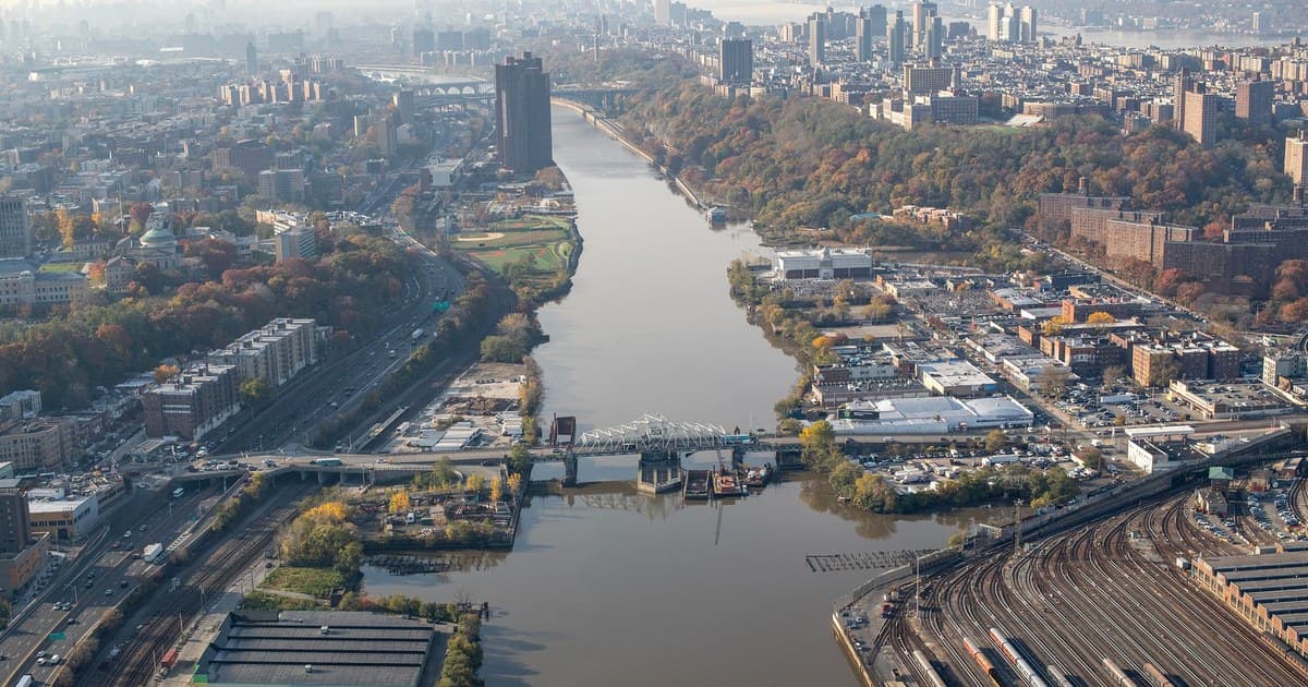 Stunning aerial view of Harlem River with Manhattan in the distance, showcasing New York's urban landscape.